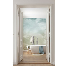 Lichte badkamer met ligbad, kruk en behang met wolkenpatroon, gezien door een open deur.