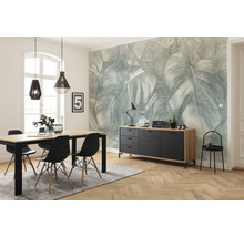 Eetkamer met eettafel, stoelen, dressoir en behang met bladerpatroon voor een lichte en georganiseerde sfeer.