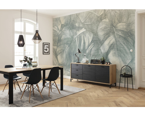 Eetkamer met eettafel, stoelen, dressoir en behang met bladerpatroon voor een lichte en georganiseerde sfeer.