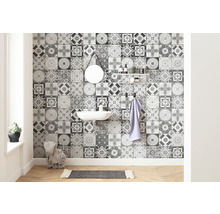 Badkamer met wastafel, spiegel, plank en wandtegels met een ornamentaal patroon