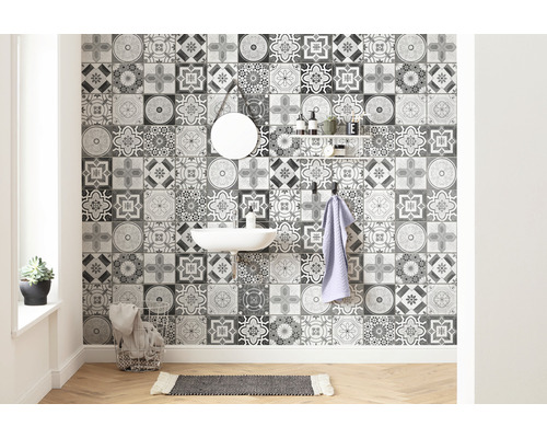 Badkamer met wastafel, spiegel, plank en wandtegels met een ornamentaal patroon