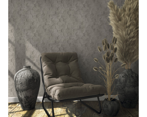 Scene met fauteuil, vazen en decoratieve grassen voor een muur met zeshoekig patroon.