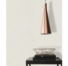 Close-up van een muur met textielbehang, gecombineerd met een hanglamp en decoratieve elementen op een tafel