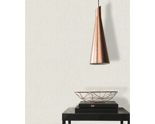 Close-up van een muur met textielbehang, gecombineerd met een hanglamp en decoratieve elementen op een tafel