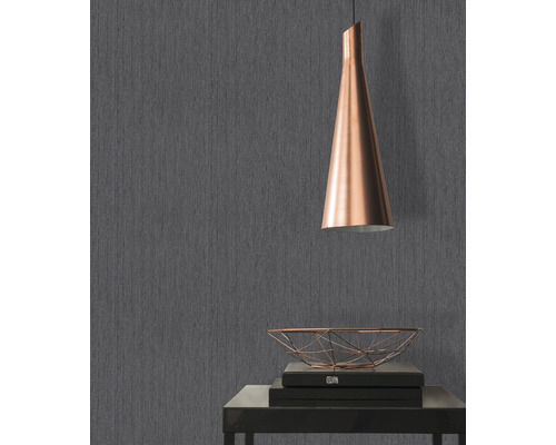 Grijs behang met textielstructuur, tafel met decoratie en lamp