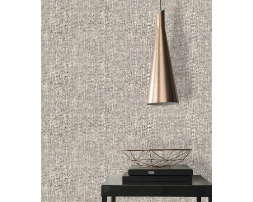 Close-up van een gestructureerd behang met een lamp en decoratieve objecten op een tafel