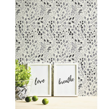 Behang met plantenmotief achter twee ingelijste kunstprints
