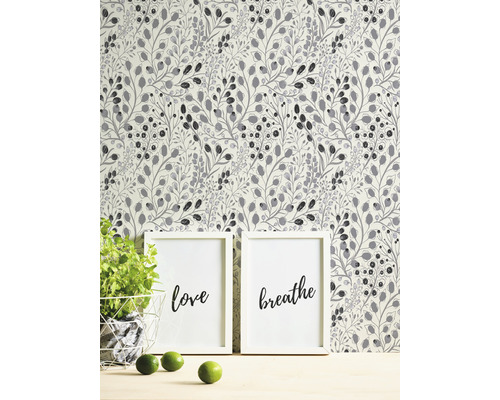 Behang met plantenmotief achter twee ingelijste kunstprints