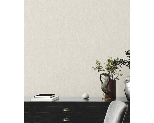 Close-up van een muur met textielbehang in een lichte tint, dat een gestructureerde uitstraling biedt.