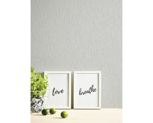 Decoratieve scène met twee ingelijste letterafbeeldingen, potplant en limoenen voor een wand