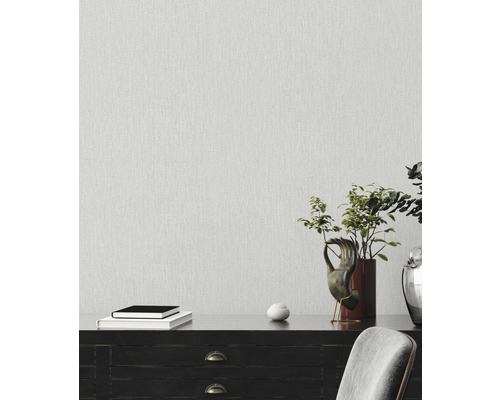 Decoratief interieur met gestructureerd behang op de muur, boeken op een donker dressoir met potplant en decoraties