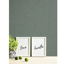 Close-up van een grijs textielbehang met twee foto''s, een plant en limoenen