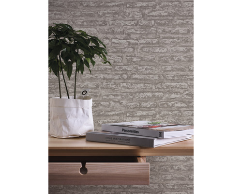 Kamer met behang in steenlook, tafel, plant en boeken