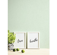 Decoratieve scène met ingelijste kunstdrukken, potplant en limoenen