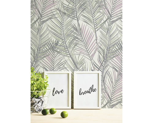 Scene met palmbladmotiefbehang, twee fotolijsten met de opschriften liefde en adem, potplant en limoenen