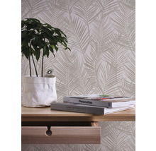 Decoratief behang met palmmotief in woonkamer met tafel en plant.