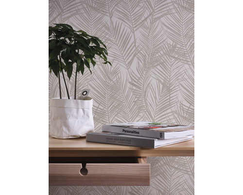 Decoratief behang met palmmotief in woonkamer met tafel en plant.