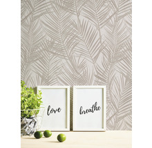 Wand met palmboompatroonbehang, twee fotolijsten met de inscripties liefde en ademen