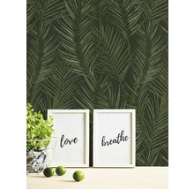 Behang met tropisch palmmotief, gecombineerd met decoratieve elementen zoals fotolijsten en een potplant