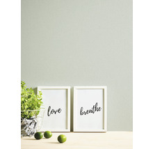 Decoratieve scène met kruidenpot, citroenen en ingelijste kunstprints met de opschriften liefde en ademen.