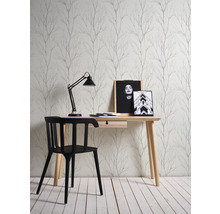 Een werkkamer met een bureau, een stoel en behang met een boommotief.