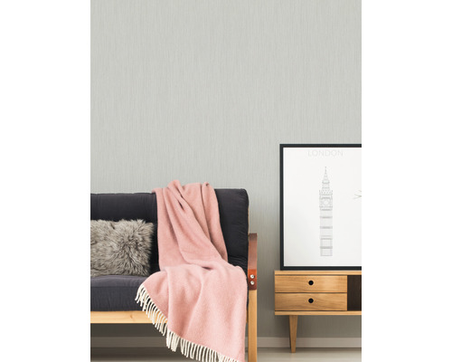 Lichte kamer met grijs behang, bank, deken en bijzettafel