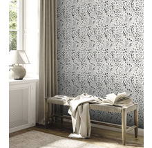 Decoratieve kamer met behangmotief, bank en raam voor een lichte en uitnodigende sfeer.