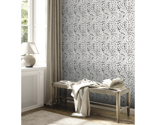 Decoratieve kamer met behangmotief, bank en raam voor een lichte en uitnodigende sfeer.