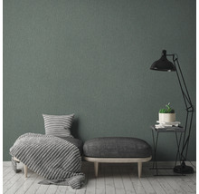 Woonkamer met grijs textielbehang, fauteuil, hocker en staande lamp