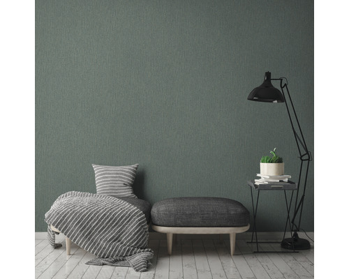 Woonkamer met grijs textielbehang, fauteuil, hocker en staande lamp