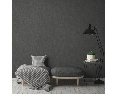 Grijs textielbehang in slaapkamer met fauteuil, kruk en staande lamp