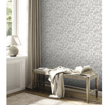 Woonkamer met bloemetjesbehang, bank en decoratie