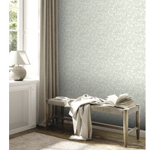 Lichte kamer met bloemenbehang, bank en decoratieve elementen.