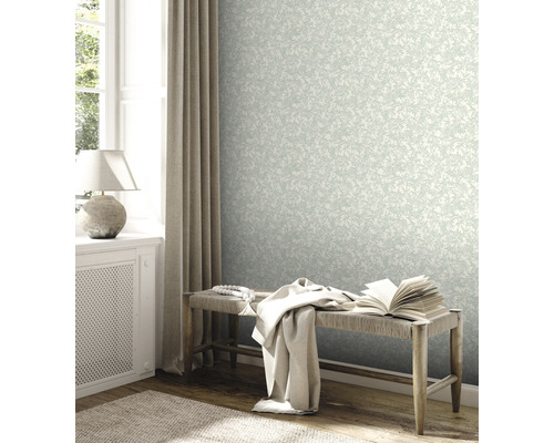 Lichte kamer met bloemenbehang, bank en decoratieve elementen.