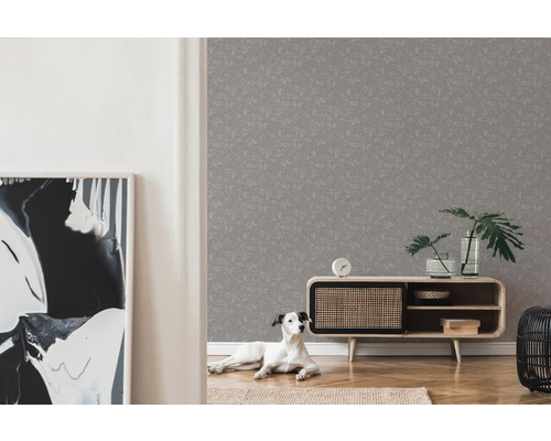 Woonkamer met grijs patroonbehang, dressoir, kamerplanten en hond