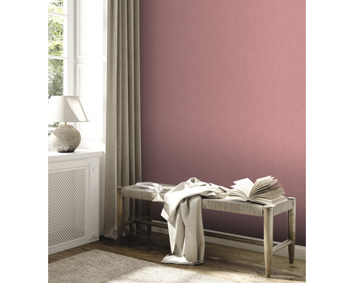 Woonkamer met gemustered behang, bank en raam voor een gezellige sfeer.