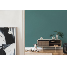 Woonkamer met petroleumkleurige muur, dressoir en hond