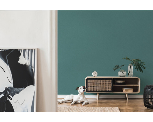 Woonkamer met petroleumkleurige muur, dressoir en hond