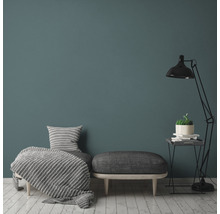 Woonkamer met fauteuil, kruk, vloerlamp en decoratie