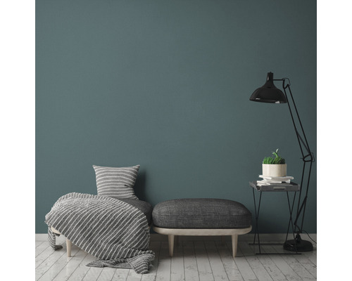 Woonkamer met fauteuil, kruk, vloerlamp en decoratie