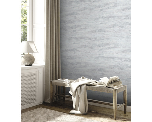 Woonkamer met behangmotief, bank en decoratie voor een lichte sfeer.