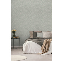 Slaapkamer met patroonbehang, bed en bijzettafel met bloemen