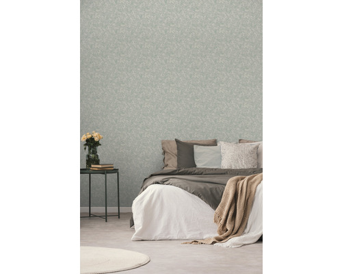 Slaapkamer met patroonbehang, bed en bijzettafel met bloemen