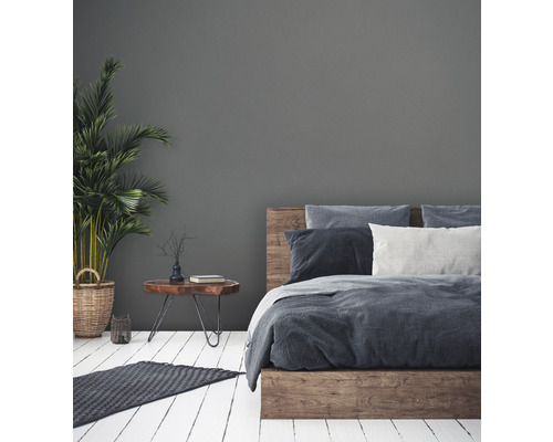 Slaapkamer met houten bed, nachtkastje en kamerplant