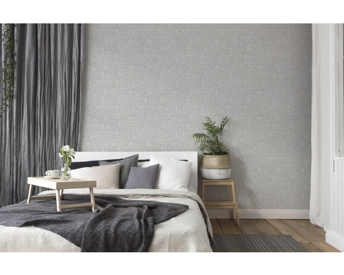 Lichte slaapkamer met grijs textielbehang, bed en houten vloer
