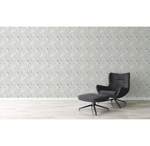 Woonkamer met bloemenbehang en fauteuil met voetenbank