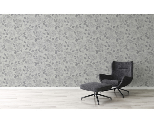 Kamerweergave met bloemenbehang en fauteuil met voetenbank