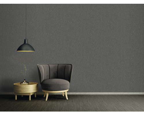 Woonkamer met grijs structuurbehang, fauteuil, bijzettafel en hanglamp