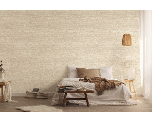 Slaapkamer met een muurbehang in steenlook en een bed