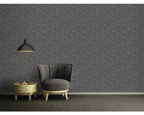 Woonkamer met patroonbehang, fauteuil en hanglamp